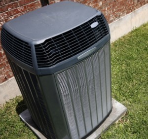 Heat pump installed outside a brick home.