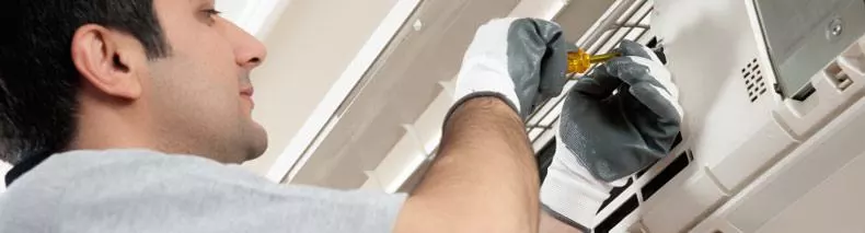 A technician repairing a ductless mini-split AC