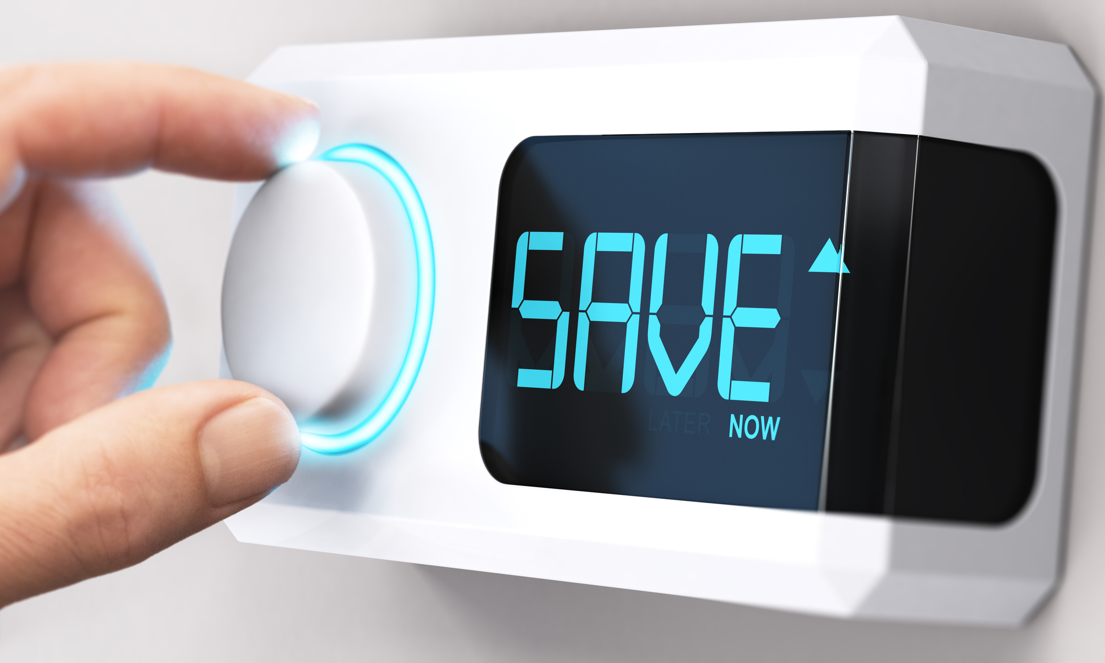 Hand turning a thermostat knob. The display on the thermostat says, "save now."